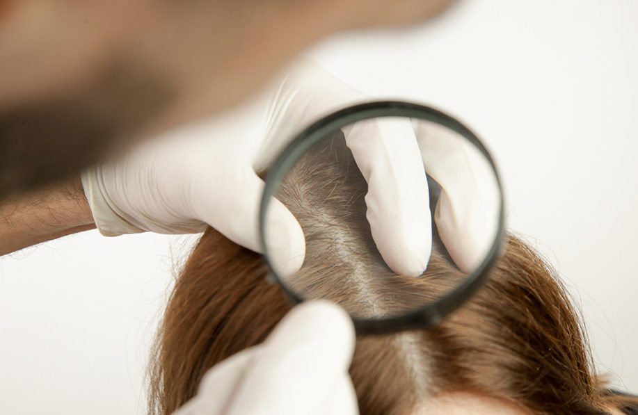 Examining woman's scalp.